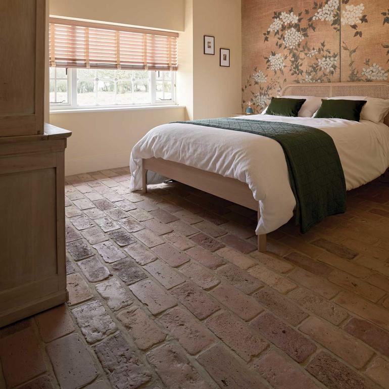 Recycled terracotta pavers are used as sustainable flooring in one of the bedrooms