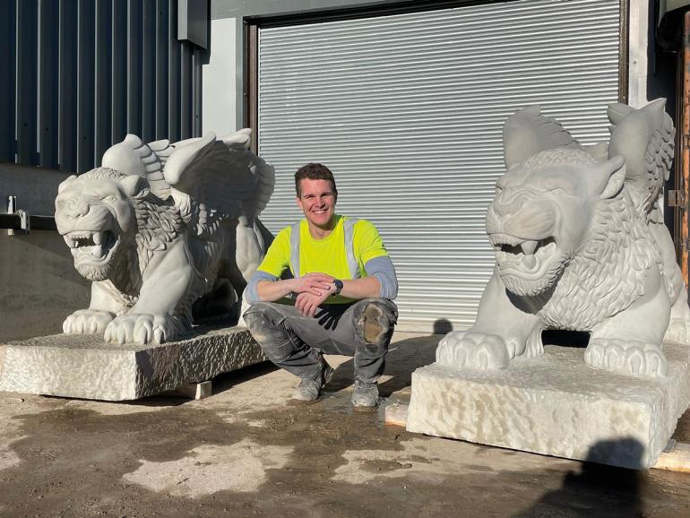 Ryan outside his workshop at Traditional Stone with the two completed griffins