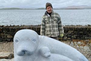 Victor Daly with sculpture of seal and pup